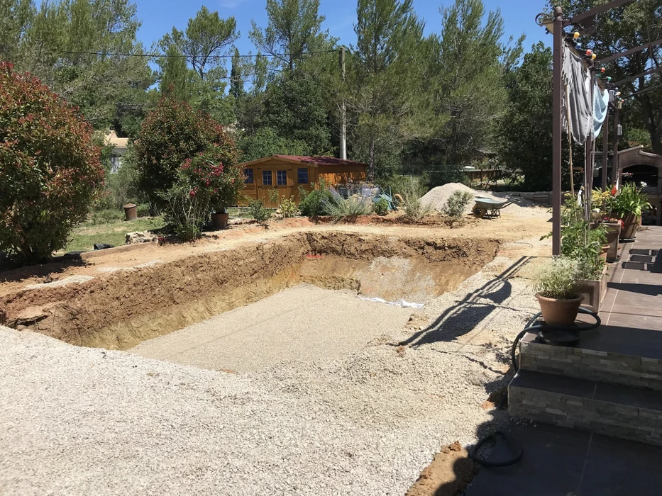 Chantier de construction de piscine en cours d'excavation dans jardin résidentiel
