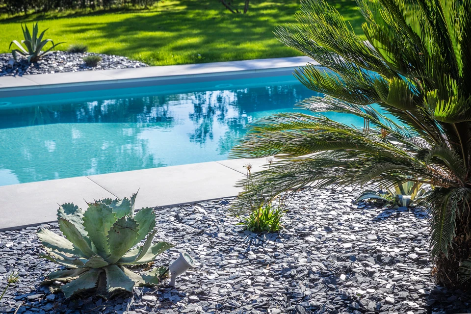 Homme d'affaires souriant au téléphone dans un entrepôt de commerce électronique, assis à un bureau avec ordinateur portable ouvert