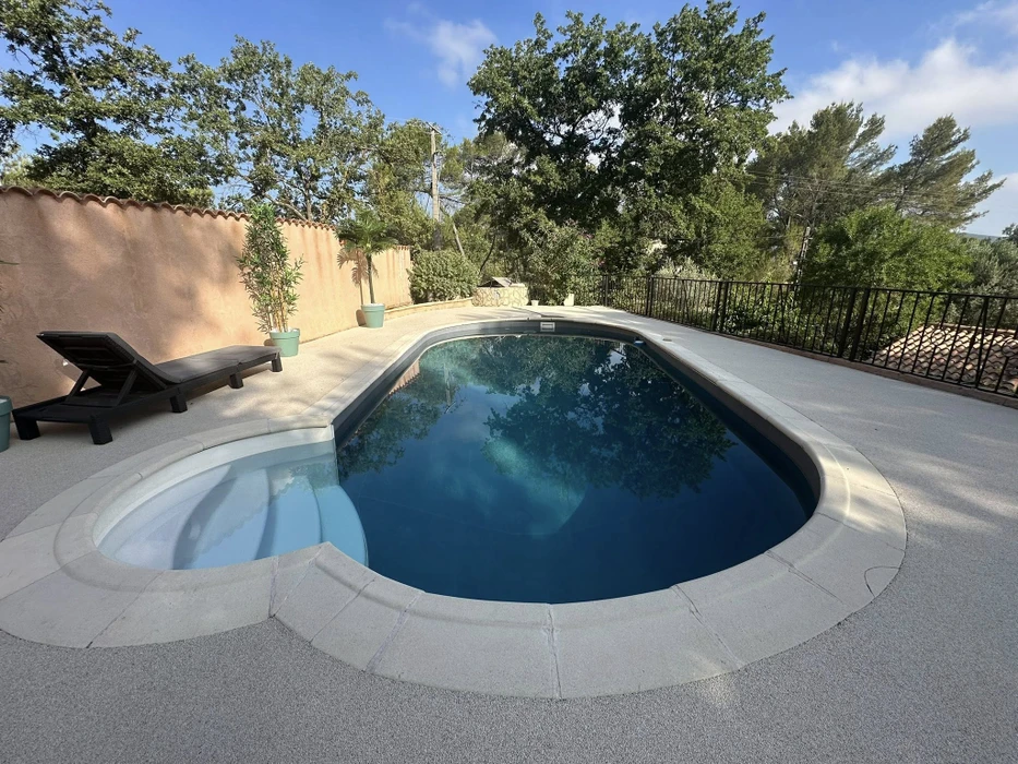 Piscine rectangulaire en construction dans jardin résidentiel avec margelles en pierre naturelle claire