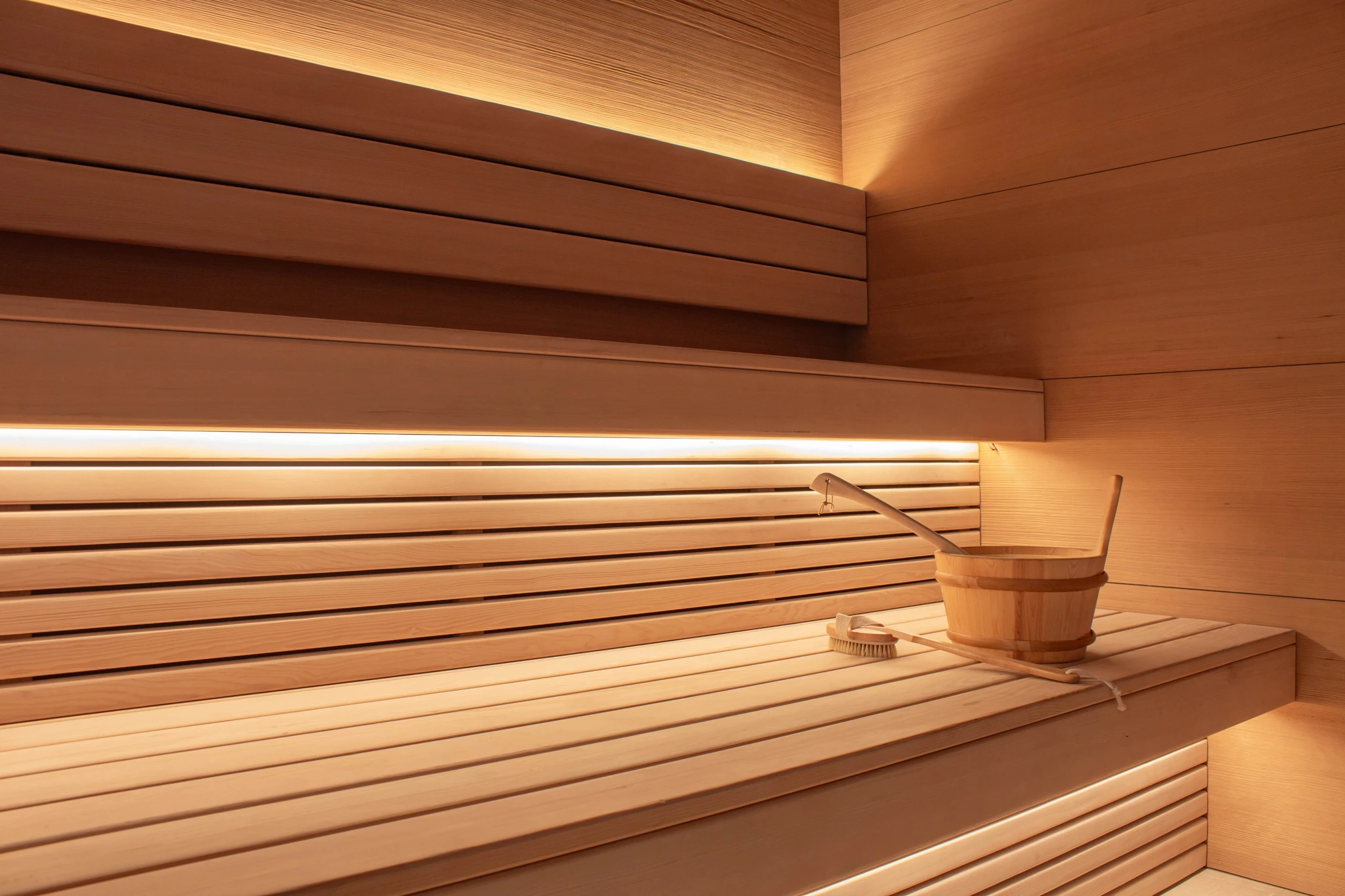 Femme en serviette blanche assise sur banc en bois dans sauna traditionnel